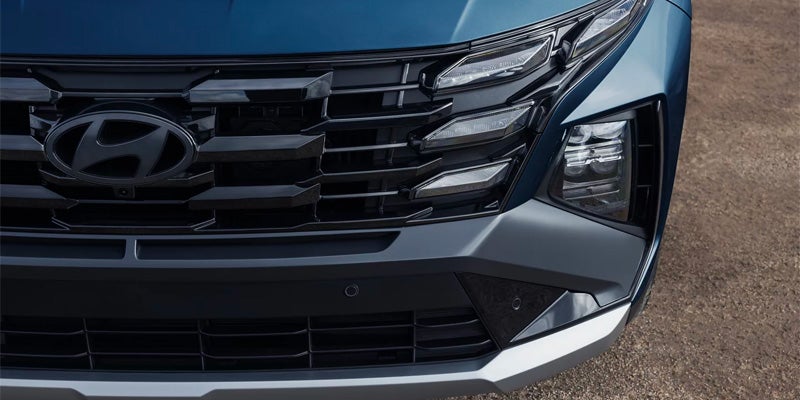 Close-up of a car's front grille, headlights, and bumper.